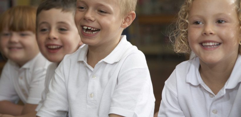 Schoolchildren (4-7) sitting in class, laughing Schoolchildren (4-7) sitting in class, laughing